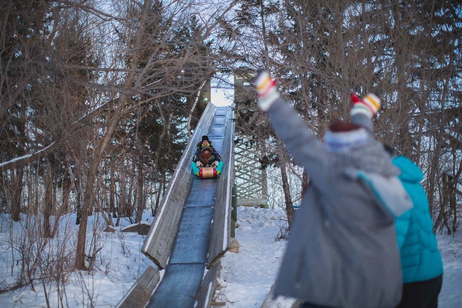 Friends waving to another sliding down the toboggan run