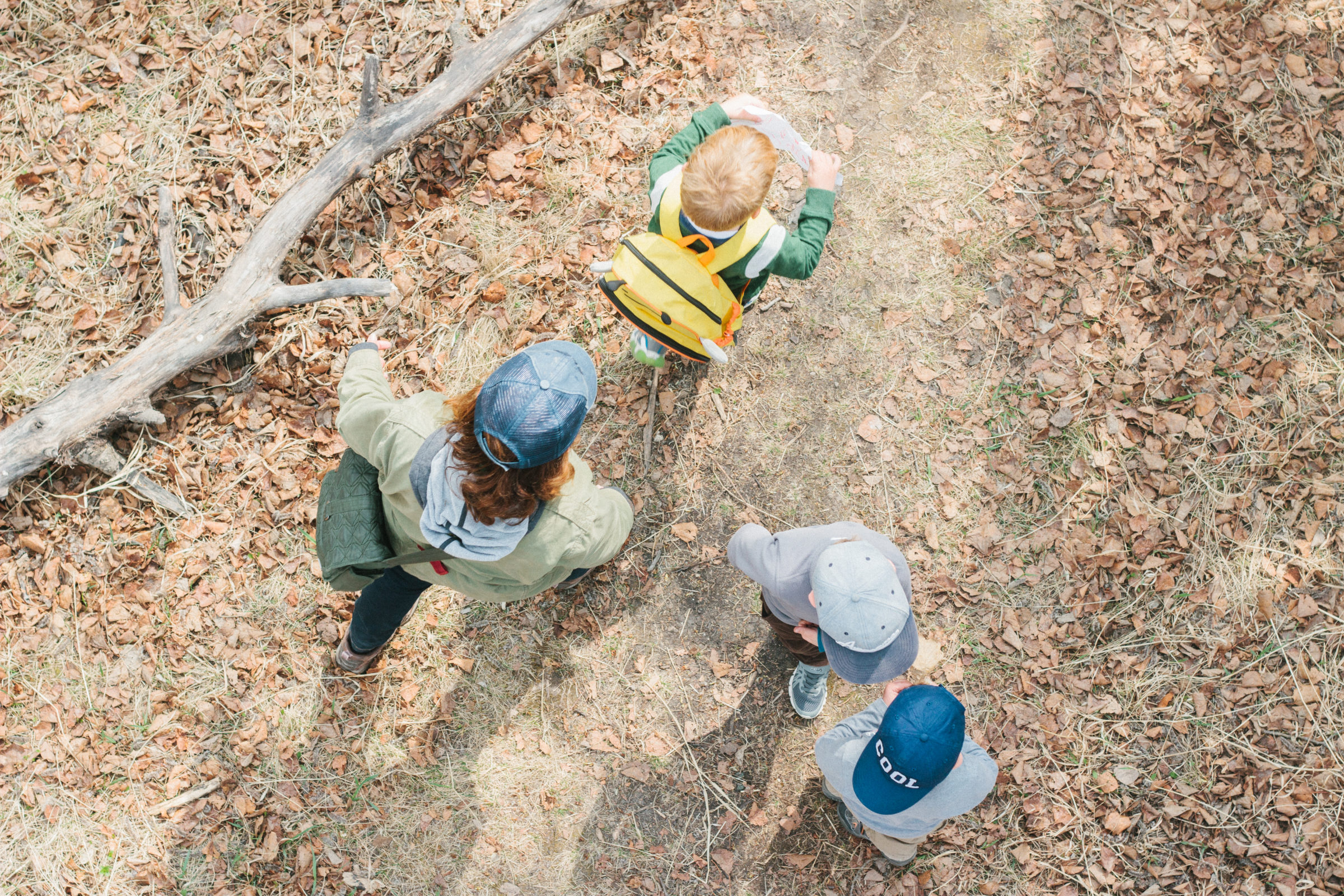 Overhead shot of adult with 3 young children walking the trails