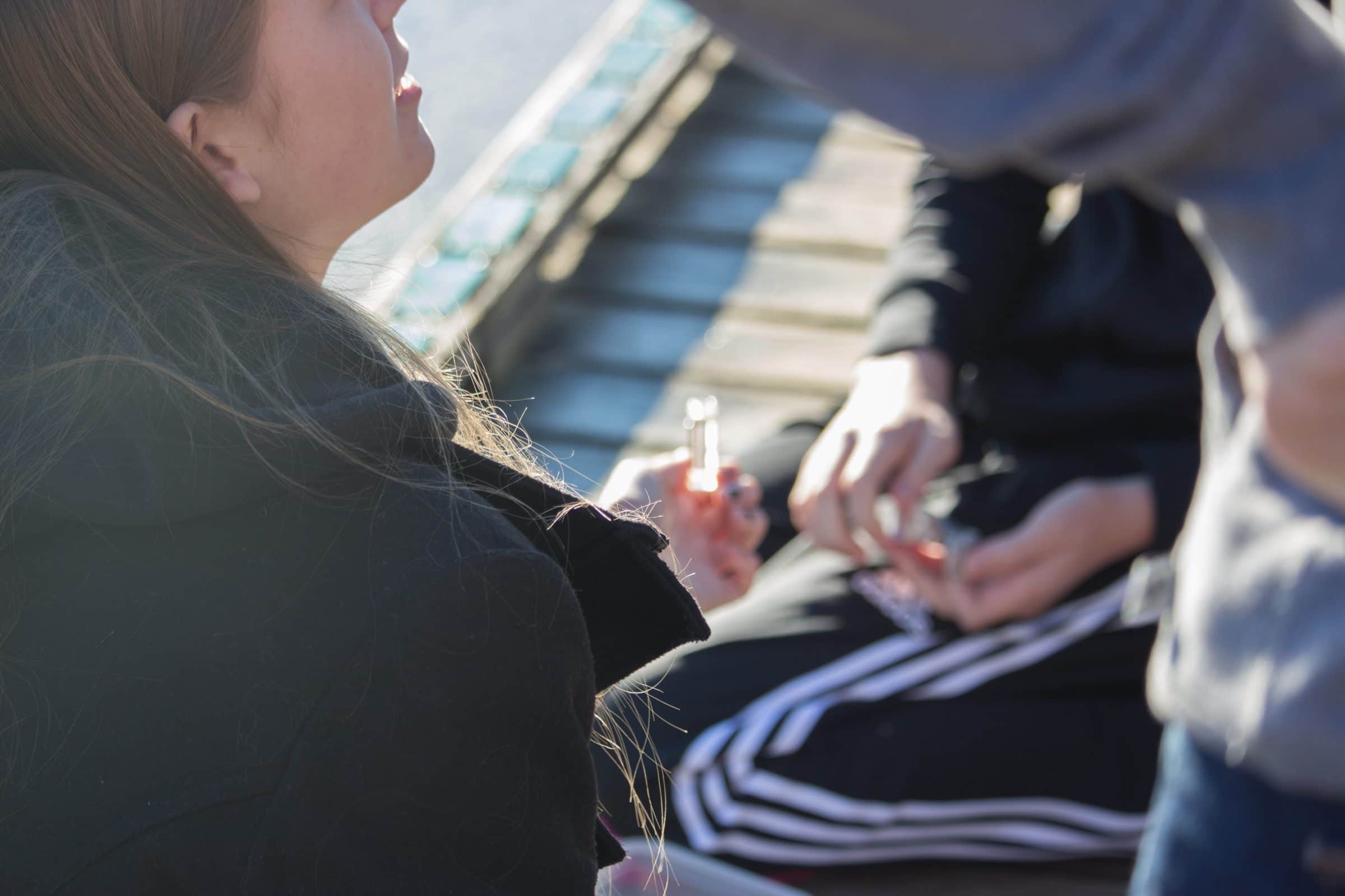 Teenage students sitting on the boardwalk holding a clear tube