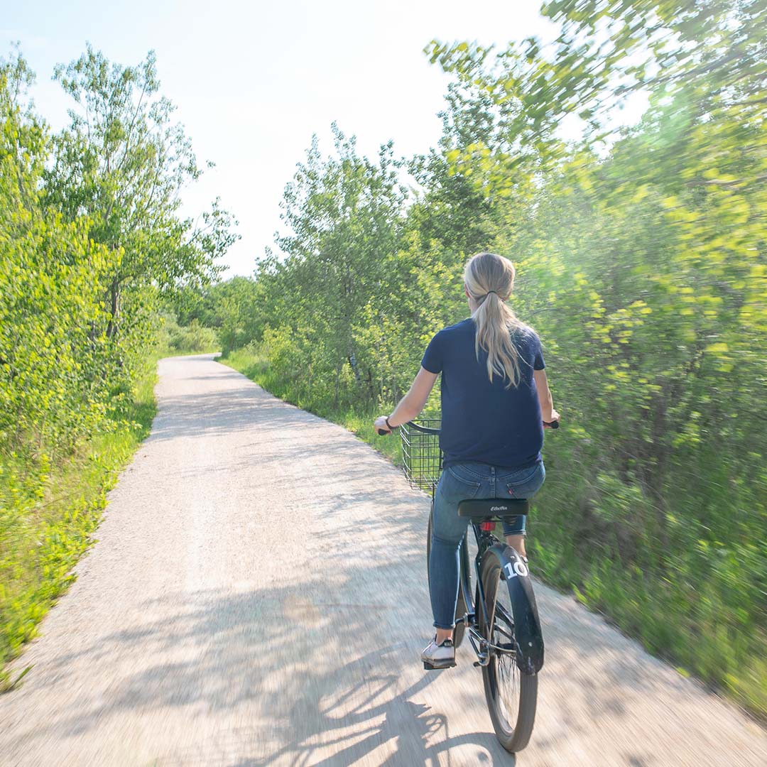 Visitor biking on the trail in summer