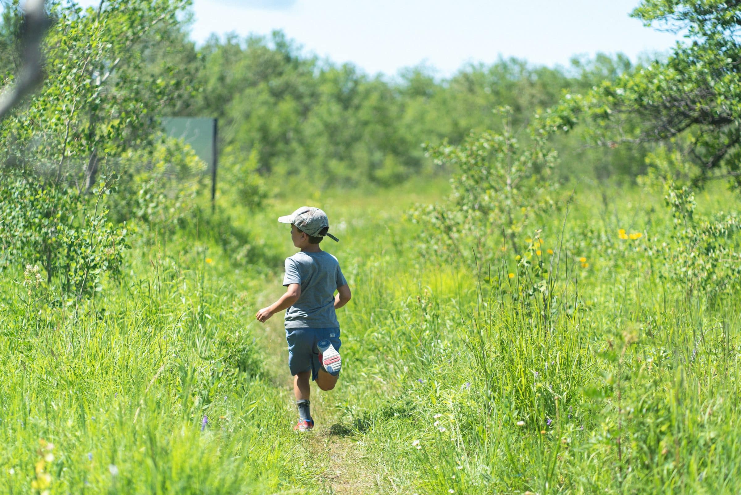 A child running on a grassy trail
