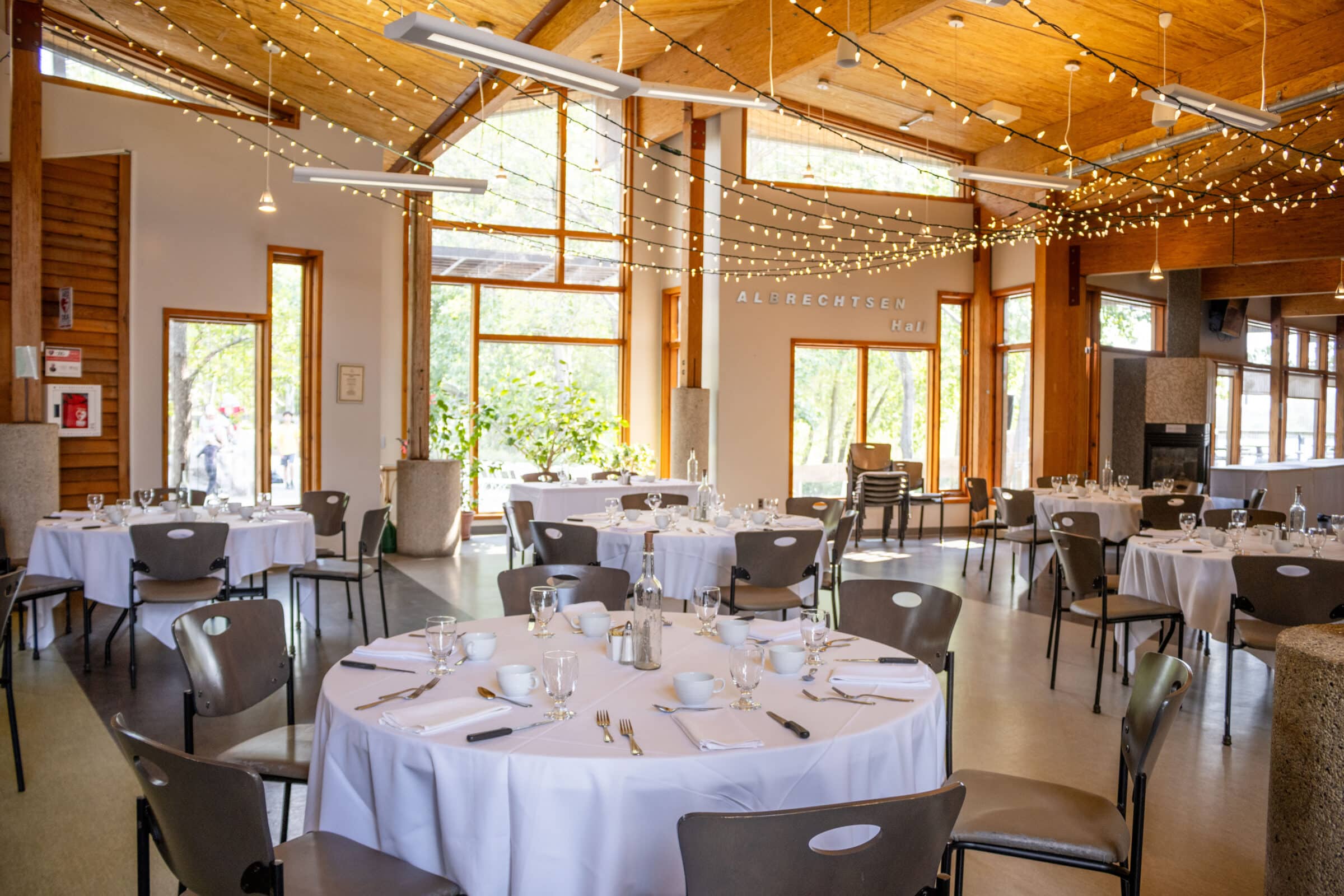 reception centre set with tables covered with linens and place settings